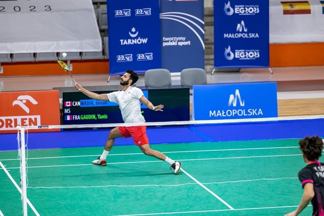 Imran Wadia stretching low for a forehand shot during a men's singles match at an international tournament